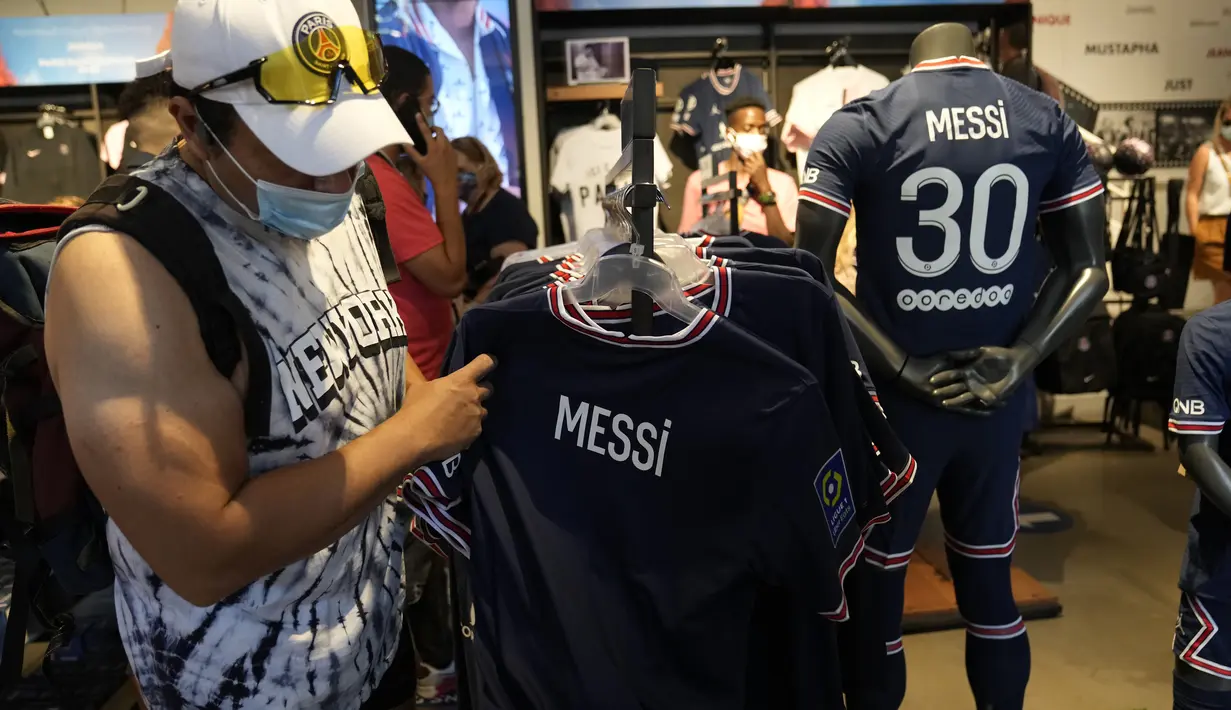 Suporter Paris Saint-Germain memeriksa jersey bertuliskan nama Lionel Messi di toko resmi PSG, di Paris, Rabu (11/8/2021). Penjualan jersey PSG dengan nama Messi dan nomor punggung 30 laris manis, bahkan fans rela antre panjang. (AP Photo/Francois Mori)