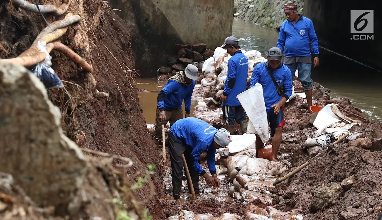 Petugas membongkar dinding turap di saluran air kawasan Pancoran, Jakarta, Senin (28/1). Pembongkaran dilakukan untuk mengganti batu penahan turap guna mencegah kelongsoran selama musim hujan. (Liputan6.com/Immanuel Antonius)