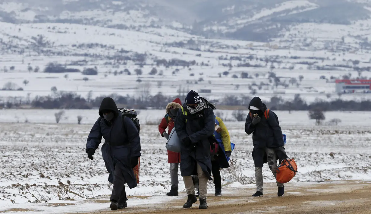 Sejumlah imigran berjalan melewati hamparan salju setelah menyeberang dari perbatasan Macedonia di dekat desa Miratovac, Serbia, (18/1/2016). (REUTERS/Marko Djurica)