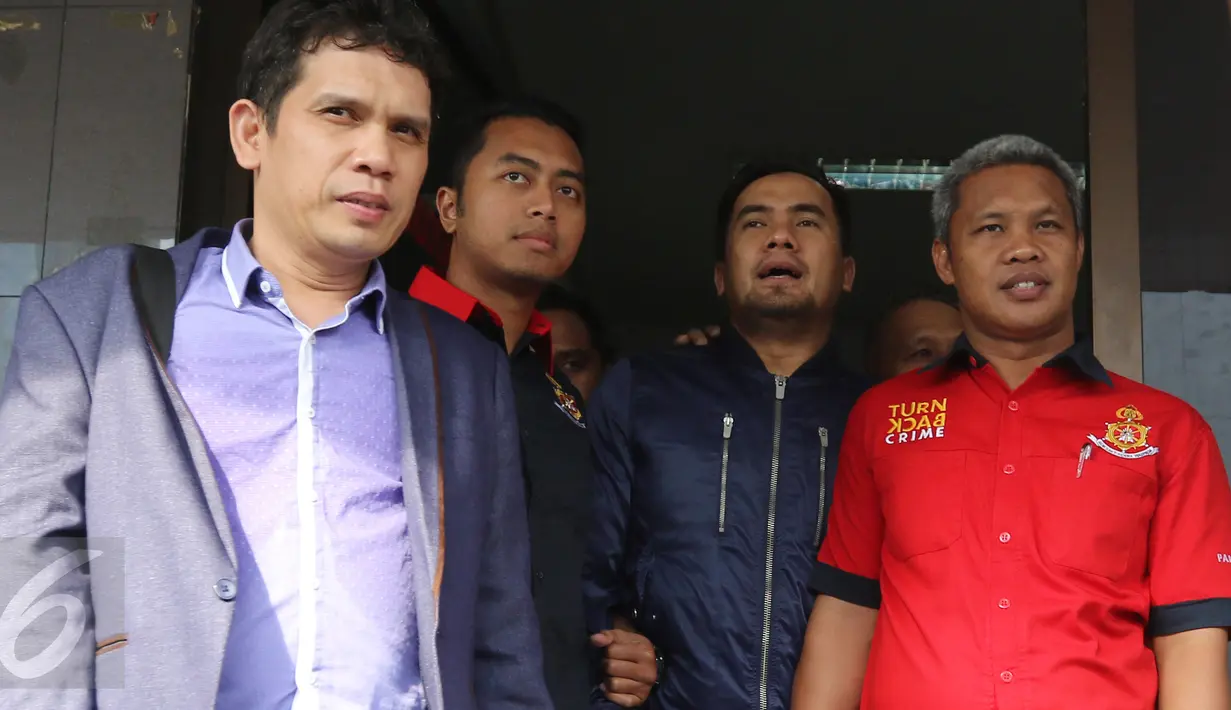 Pedangdut Saipul Jamil (kedua kanan) dikawal oleh petugas kepolisian saat menjalani pemeriksaan kesehatan di gedung Kedokteran dan kesehatan, (20/2). Saipul Jamil harus menjalani beberapa pemeriksaan dalam kasus pencabulan. (Liputan6.com/Herman Zakharia)