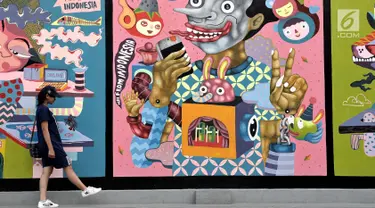 Pengunjung melintas di depan mural karya seniman Yogyakarta yang bertajuk INDONESIA IS GREAT  di museum Galeri Nasional, Jakarta, Sabtu (22/7). Pameran Mural tersebut merupakan agenda rutin museum Galeri Nasional. (Liputan6.com/Helmi Afandi)