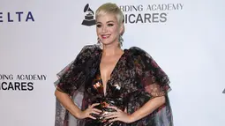 Penyanyi Katy Perry tersenyum saat berpose menghadiri pesta Gala Musicares Person of The Year 2019 di Los Angeles (8/2). Katy Perry tampil menawan mengenakan gaun hitam bermotif kembang dengan belahan hingga paha terbuka. (AFP Photo/Valerie Macon)
