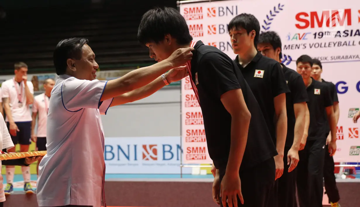 Ketua PBVSI, Imam Sudjarwo mengalungkan medali kepada pemain timnas Jepang usai gelaran Kejuaraan Voli Putra Asia 2017 di GOR Tri Dharma, Gresik, Selasa (1/8). Jepang menjadi kampiun usai menumbangkan Kazakhstan 3-1. (Liputan6.com/Helmi Fithriansyah)