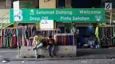 Pedagang menunggu pembeli di depan Gedung Pasar Tanah Abang, Jakarta, Jumat (22/6). Sebagian pedagang terpaksa menggelar lapak di luar gedung akibat belum dibukanya kembali Pasar Tanah Abang usai Lebaran. (Liputan6.com/Immanuel Antonius)