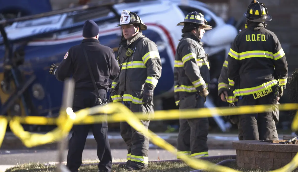 Petugas pemadam kebakaran berkumpul di tempat kejadian setelah sebuah helikopter medis jatuh di dekat Gereja Drexel Hill United Methodist Church di Drexel Hill, Philadelphia, Pennsylvania, AS (11/1/2022). (Monica Herndon/The Philadelphia Inquirer via AP)