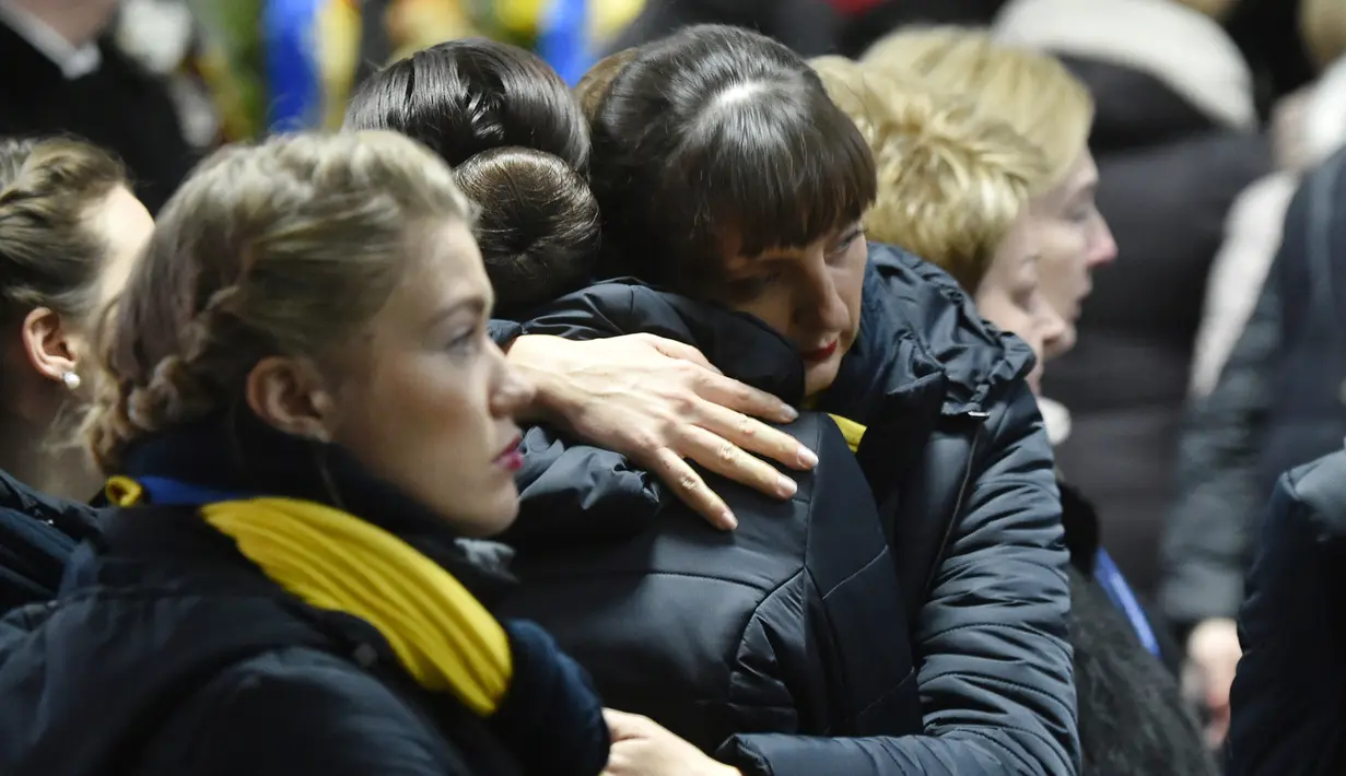 Keluarga korban menghadiri upacara penghormatan 11 warga Ukraina yang tewas dalam insiden jatuhnya pesawat Ukraine International Airlines di Iran (8/1) lalu, Bandara Boryspil Kiev, Ukraina, Minggu (19/1/2020). Pesawat tersebut jatuh oleh rudal pasukan IRGC. (Sergei SUPINSKY / AFP)