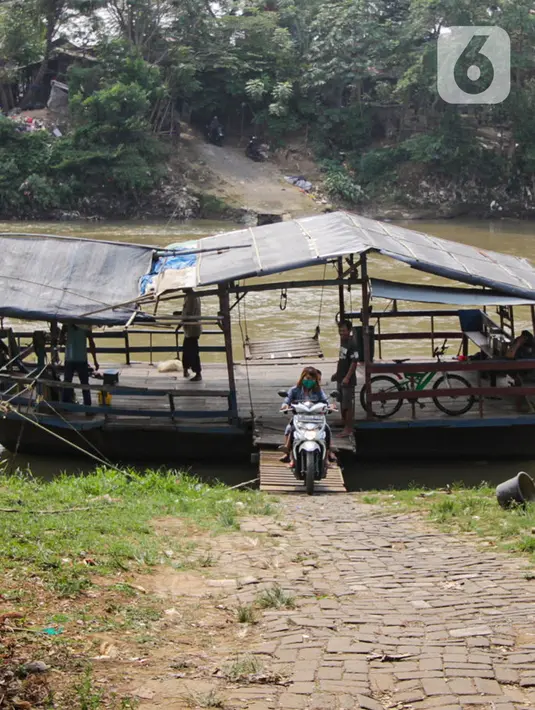 Warga turun dari perahu eretan di Sungai Cisadane, Neglasari, Kota Tangerang, Kamis (7/10/2021). Warga di kawasan tersebut masih memanfaatkan jasa penyeberangan perahu eretan untuk menyebrangi Sungai Cisadane. (Liputan6.com/Angga Yuniar)