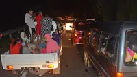 Warga menaiki mobil bak mengungsi ke tempat yang lebih tinggi menyusul terjadinya gempa di Cilacap, Jawa Tengah (16/12). Gempa berkekuatan 6,9 SR yang mengguncang Pulau Jawa membuat warga berada di apartemen panik. (AP Photo / Wagino)