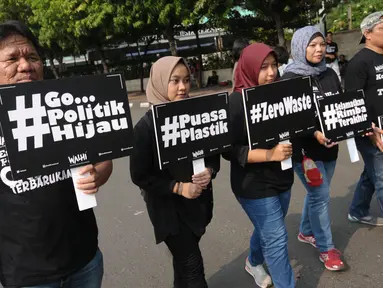 Sejumlah aktivis Walhi berjalan mengampanyekan pengurangan penggunaan plastik di kawasan Bundaran Hotel Indonesia, Jakarta, Minggu (6/3). Mereka mengajak masyarakat mengurangi penggunaan plastik. (Liputan6.com/Helmi Fithriansyah)