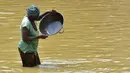 Penambang emas wanita bekerja di sungai Pampana di dekat Mekeni, Sierra Leone (5/3). Menjelang pemilihan umum di Sierra Leone, penambang berharap dari partai yang menang di pemerintahan baru agar mencari nafkah di Magburaka. (AFP Photo/Issouf Sanogo)