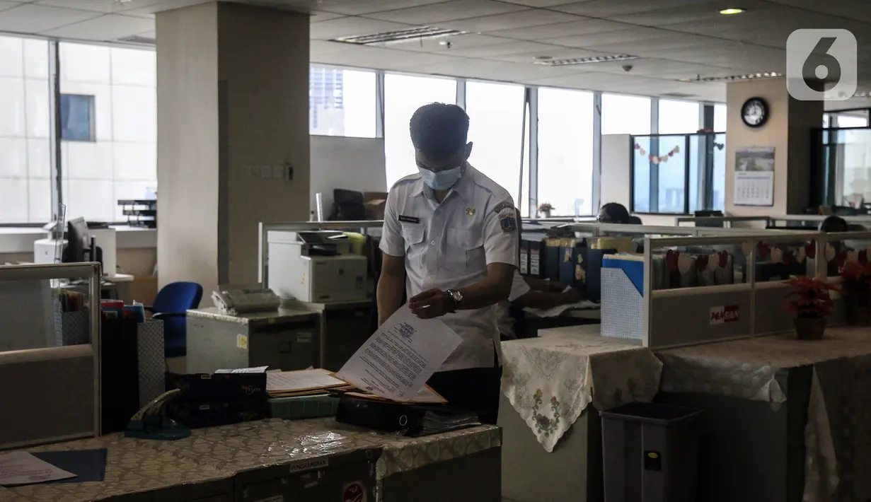 Pegawai Badan Kepegawaian Daerah DKI Jakarta menyelesaikan pekerjaannya di Kantor Balai Kota DKI Jakarta, Kamis (11/2/2021). Kementerian PANRB secara resmi melarang seluruh ASN bepergian ke luar kota saat libur Imlek guna mencegah penyebaran dan penularan COVID-19. (Liputan6.com/Johan Tallo)