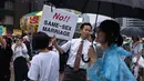 Seorang pria menunjukan poster anti-gay ditengah kerumunan peserta parade 'Gay Pride' di Seoul, Korea Selatan (15/7). Selain mereka yang merayakan parade LGBT, ada juga kelompok anti-gay yang menggelar aksi tandingan. (AFP Photo/Ed Jones)