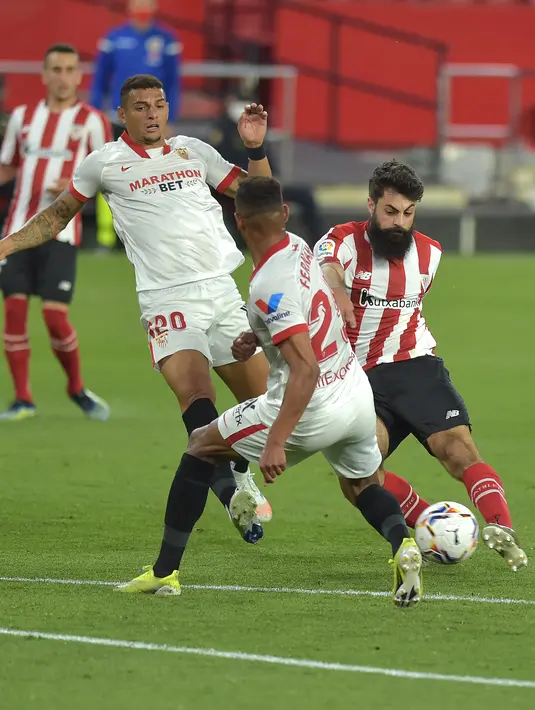 Penyerang Athletic Bilbao, Asier Villalibre berusaha melewati pemain Sevilla, Fernando dan Diego Carlos pada pertandingan lanjutan La Liga Spanyol di stadion Ramon Sanchez Pizjuan di Seville, Selasa (4/5/2021). Atletico Bilbao menang atas Sevilla 1-0. (AFP/Cristina Quicler)