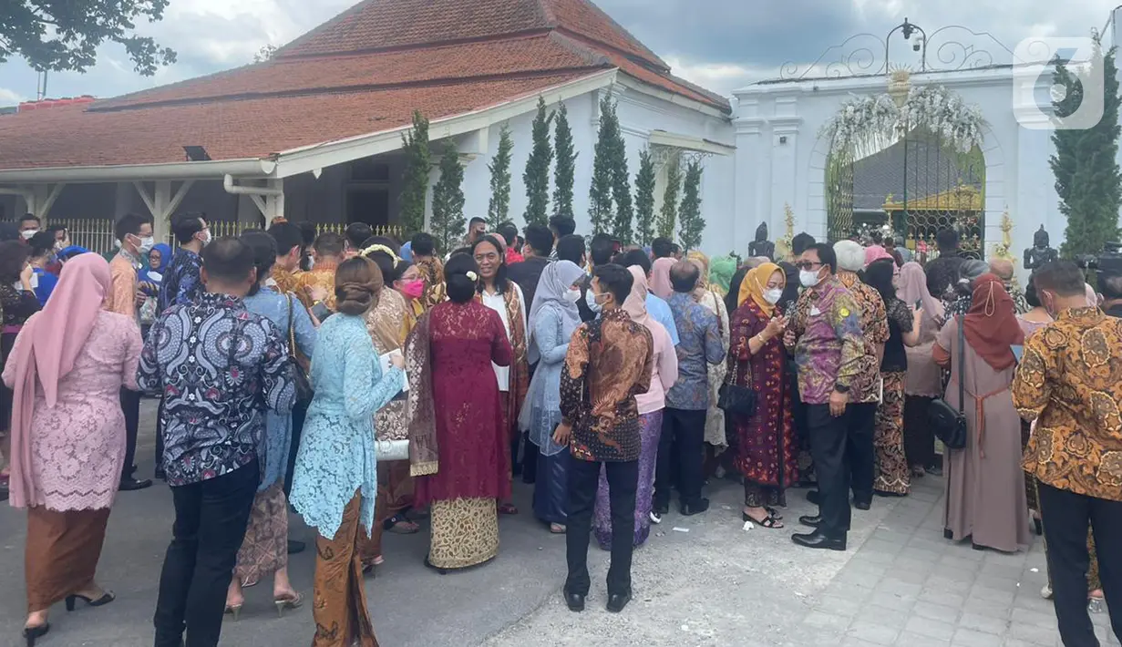 Anrean para tamu untuk memasuki lokasi resepsi pernikahan putra bungsu Presiden Jokowi, Kaesang Pangarep dan Erina Gudono di Pura Mangkunegaran Solo, Jawa Tengah, Minggu (11/12/2022). Setelah turun dari bus, para tamu langsung berjalan kaki menuju tempat pengecekan tamu undangan di sebelah barat pintu masuk Pura Mangkunegaran. (Liputan6.com/Herman Zakharia)
