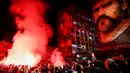 Fans merayakan ulang tahun Diego Maradona di bawah mural legenda sepak bola itu di Distrik San Giovanni, Napoli, Italia, 30 Oktober 2022. Legenda sepak bola asal Argentina, Diego Armando Maradona yang lahir pada 30 Oktober 1960 meninggal pada 25 November 2020. (Alessandro Garofalo/LaPresse via AP)