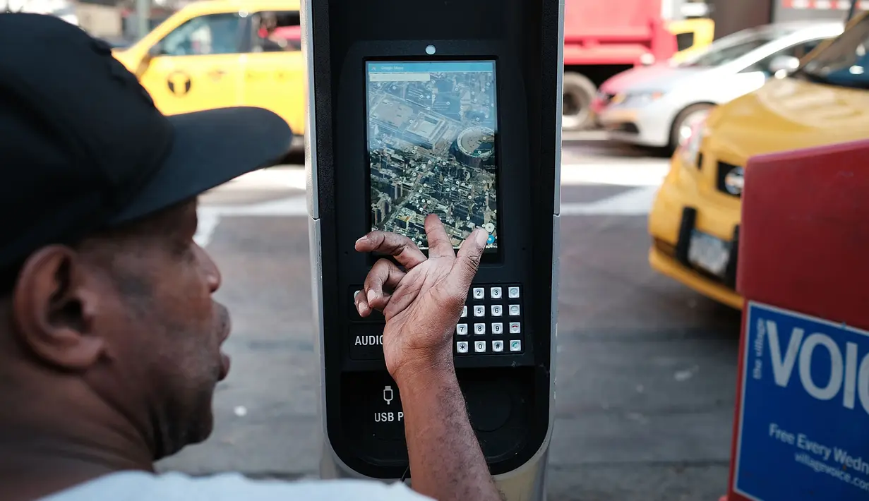 Seorang pria mengakses Google Maps di kios Wi-Fi gratis di Manhattan, New York, 24 Agustus 2016. Proyek LinkNYC ini menyulap sejumlah telepon umum usang menjadi kios Wi-Fi gratis untuk bisa mengakses internet, menelepon dan pengisian baterai ponsel. (AFP)