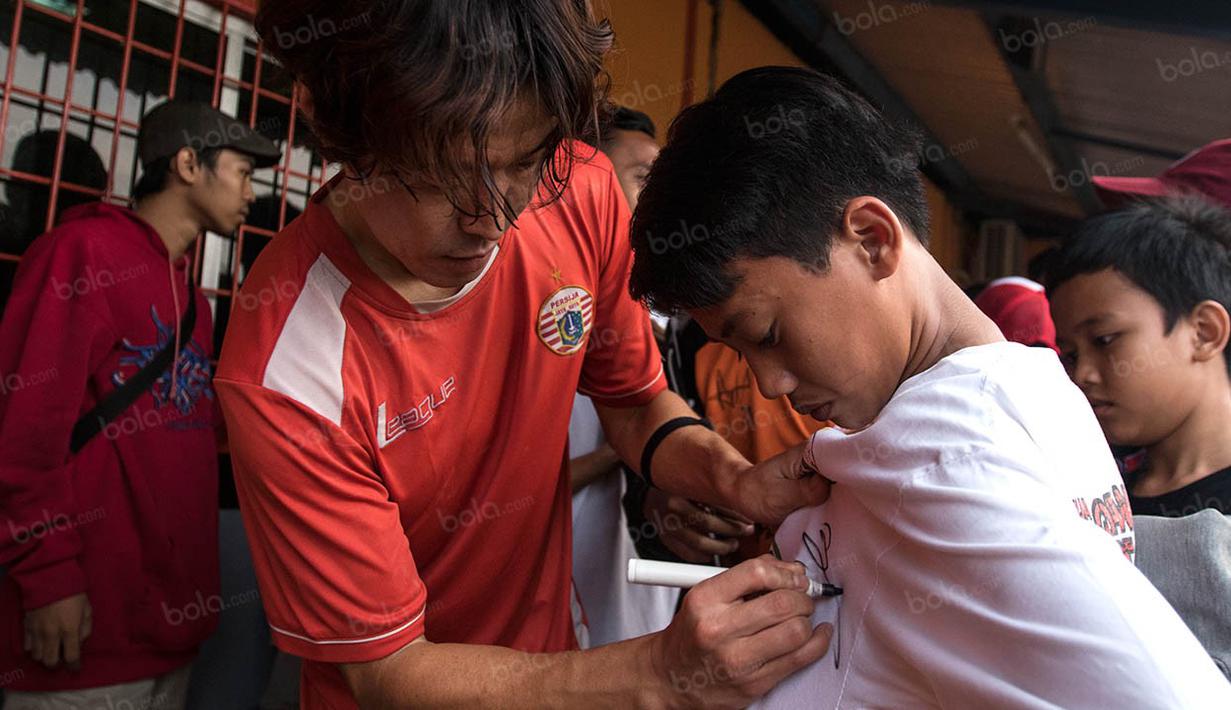 Gelandang asing Persija Jakarta, Hong Soon-hak, memberikan tanda tangan kepada suporter usai latihan jelang laga TSC 2016 melawan Persela Lamongan di Lapangan Villa 2000, Tanggerang Selatan, Banten, Selasa (13/9/2016). (Bola.com/Vitalis Yogi Trisna) 