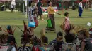 Warga melintas di depan sekelompok anak punk yang berkumpul di sebuah taman di pusat kota Yangon, Myanmar (12/4). Selain Myanmar Empat negara Asia tenggara seperti Thailand, Kamboja dan Laos juga menggelar festival air.  (AFP Photo / Roberto Schmidt)