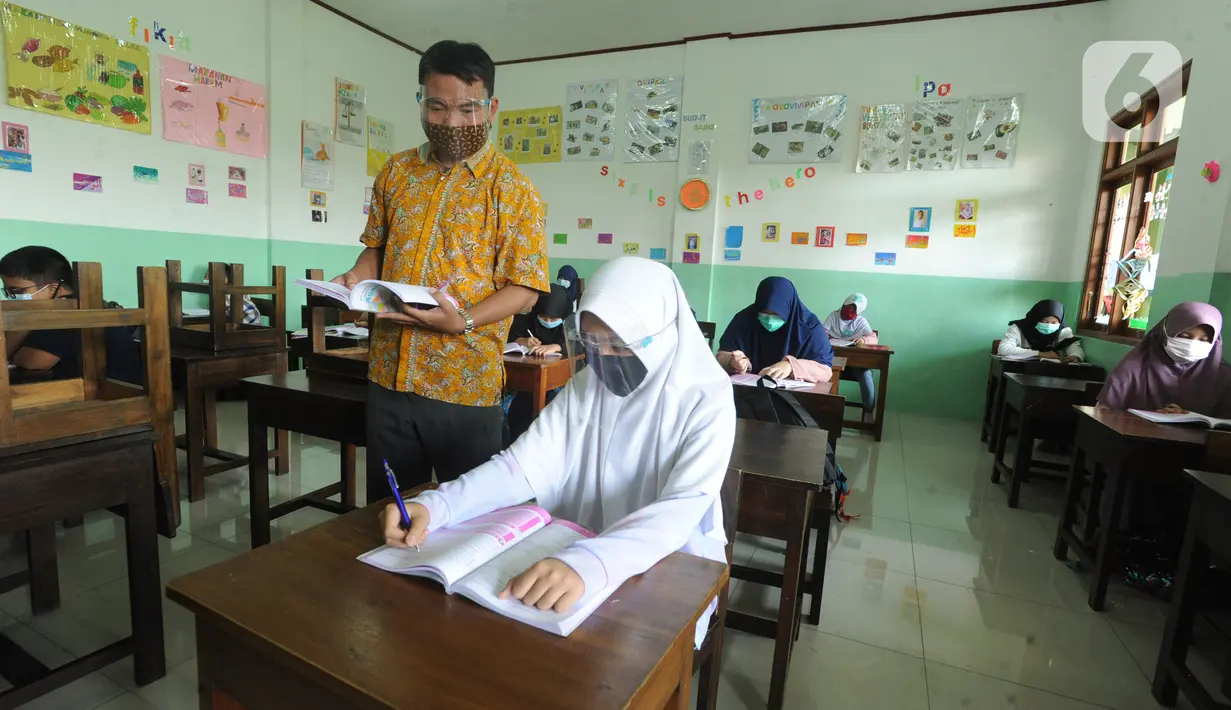 Guru mengajar secara darling sekaligus tatap muka kepada murid-murid SDIT Nurul Amal, Pondok Cabe, Tangerang Selatan, Banten, Senin (16/11/2020).  Proses belajar secara tatap muka atau luring ini merupakan uji coba dengan menggunakan assessment pembatasan jumlah murid. (merdeka.com/Arie Basuki)