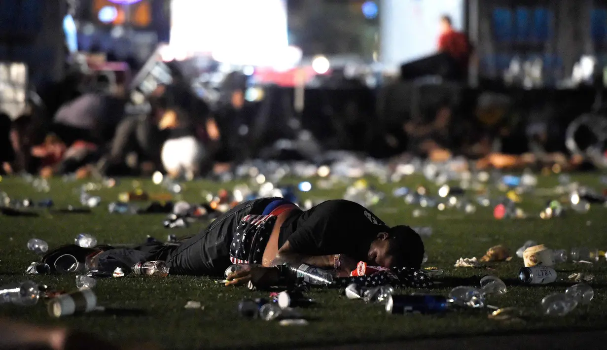 Seorang pengunjung tergeletak saat festival musik Route 91 Harvest country setelah aksi penembakan di Las Vegas, Nevada (1/10). Penembakan dilaporkan terjadi di areal Kasino Mandalay Bay, Las Vegas, Amerika Serikat. (David Becker/Getty Images/AFP)