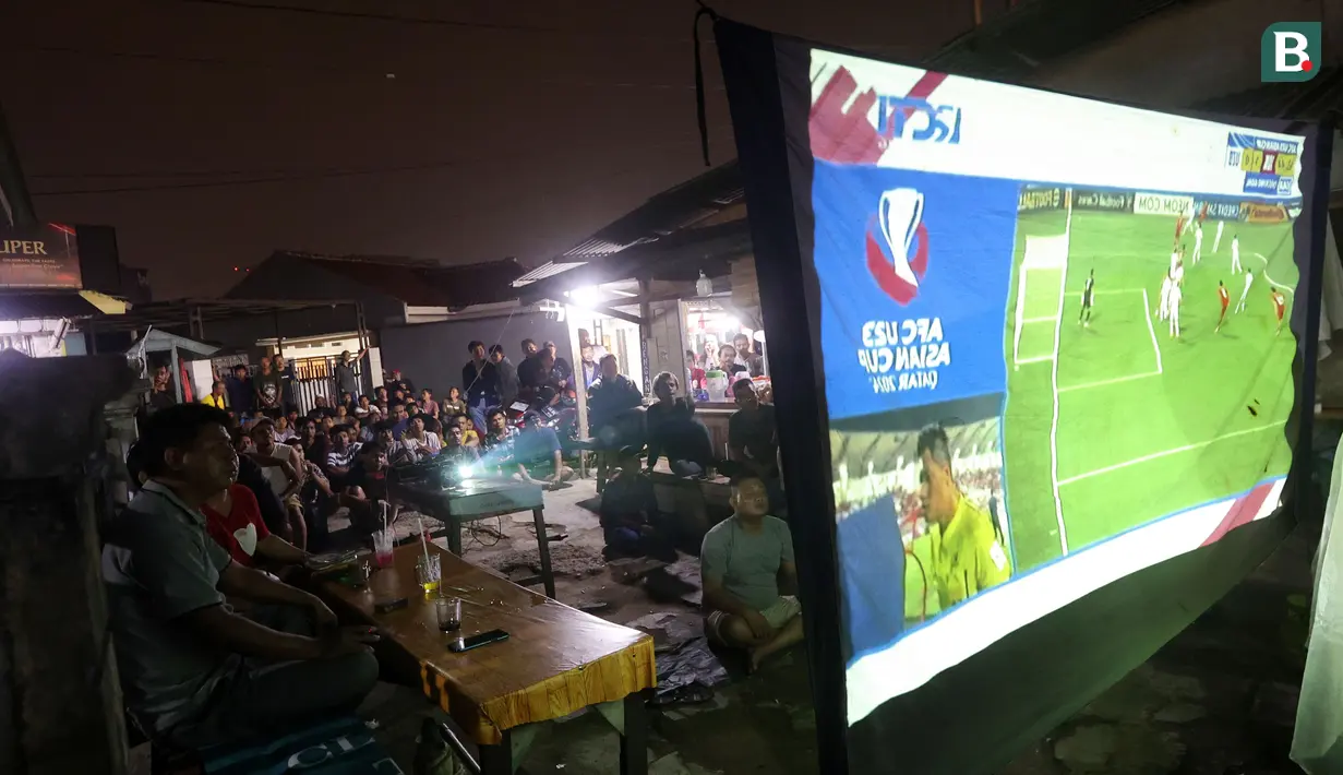 Warga asik menonton pertandingan Timnas Indonesia U-23 vs Uzbekistan di Piala Asia U-23 saat nobar di kampung Sampora, Cisauk, Tangerang, Selasa (29/4/2024). (Bola.com/M Iqbal Ichsan)