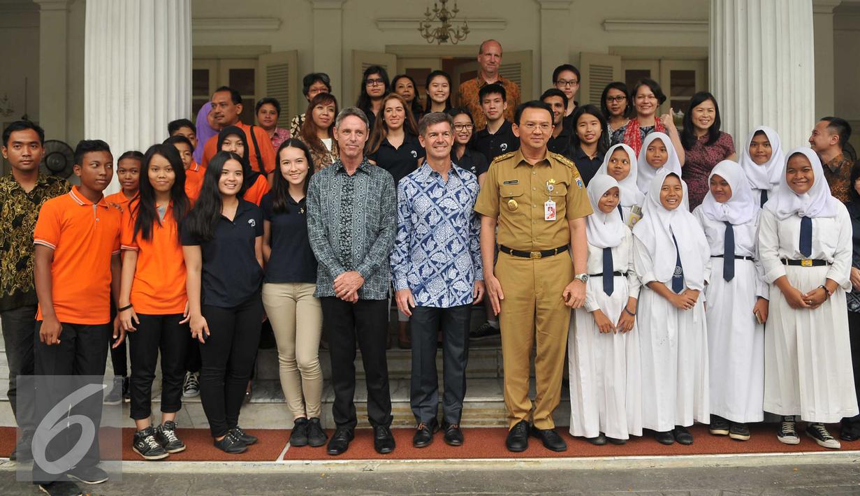 Guru dan siswa Jakarta Intercultural School (JIS) foto bersama dengan Gubernur Basuki T Purnama usai kunjungan ke Balaikota, Jakarta, Senin (21/3). Kunjungan perdana JIS ini bertujuan untuk menyampaikan komitmen sekolah. (Liputan6.com/Gempur M Surya)