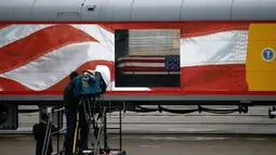 Peti jenazah Presiden ke-41 AS George HW Bush ditempatkan dalam sebuah kereta di Union Pacific Westfield, Spring, Texas, Kamis (6/12). Kereta pembawa jenazah George HW Bush menempuh perjalanan sejauh 112 kilometer. (AP Photo/Kiichiro Sato)