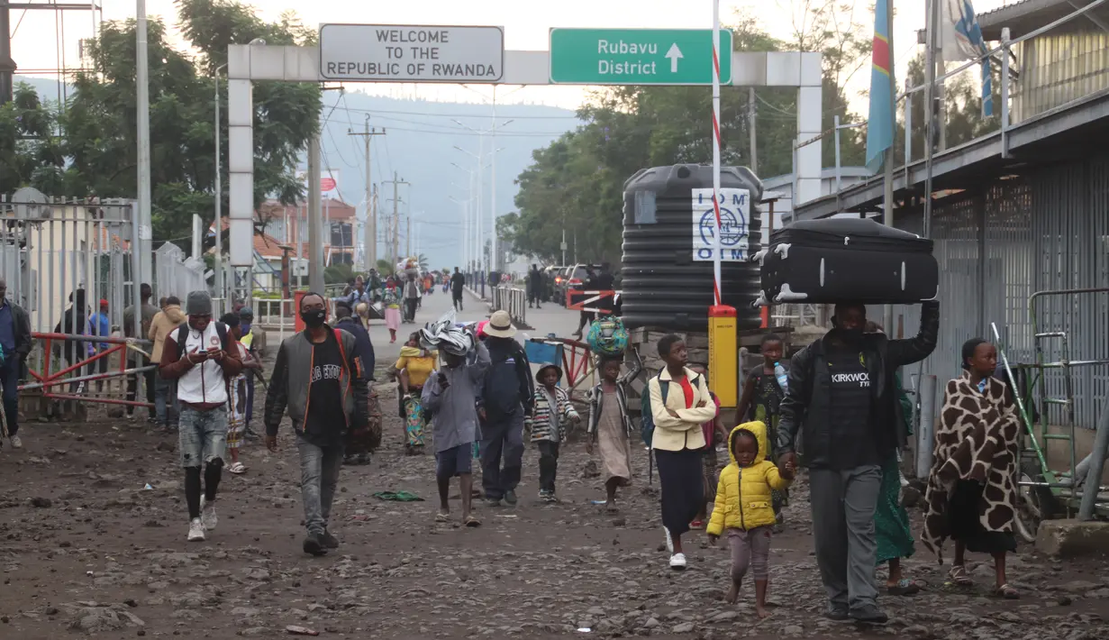 Orang-orang yang melarikan diri ke Rwanda selama letusan Gunung Nyiragongo semalam kembali ke Goma, Kongo (23/5/2021). (AP Photo/Justin Kabumba)