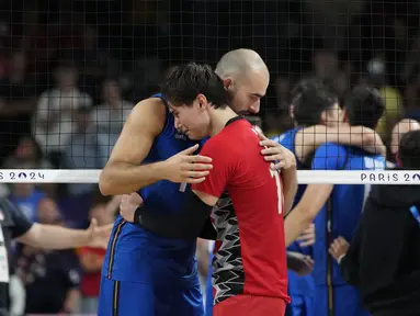 Pemain voili Italia, Gianluca Galassi menghibur Ran Takahashi, dari Jepang, pada akhir pertandingan bola voli perempat final putra Olimpiade Paris 2024 di South Paris Arena, Senin, 5 Agustus 2024. (AP Photo/Dolores Ochoa)