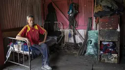 Juan Pablo Ibarra, 51, menonton televisi di kamarnya setelah mendaur ulang barang di pagi hari, di tempat pengumpulan daur ulang di pinggiran kota Buenos Aires, Argentina (14/12/2021). Pemilik tempat pengumpulan mengizinkan Ibarra untuk tinggal di sana. (AP Photo/Rodrigo Abd)