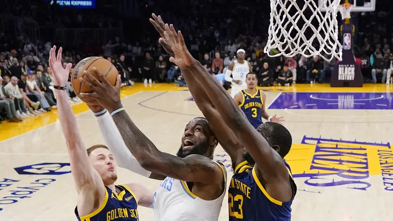 Pemain Lakers LeBron James menerobos pertahanan Warriors di lanjutan NBA
