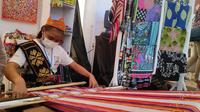 Di lokasi W20 Expo Toba, seorang penyandang disabilitas grahita, Sriwanti (17) tampak lihai menenun kain Ulos. Wanita berusia 17 tahun itu turut mengambil peran dalam kegiatan W20 Expo Toba