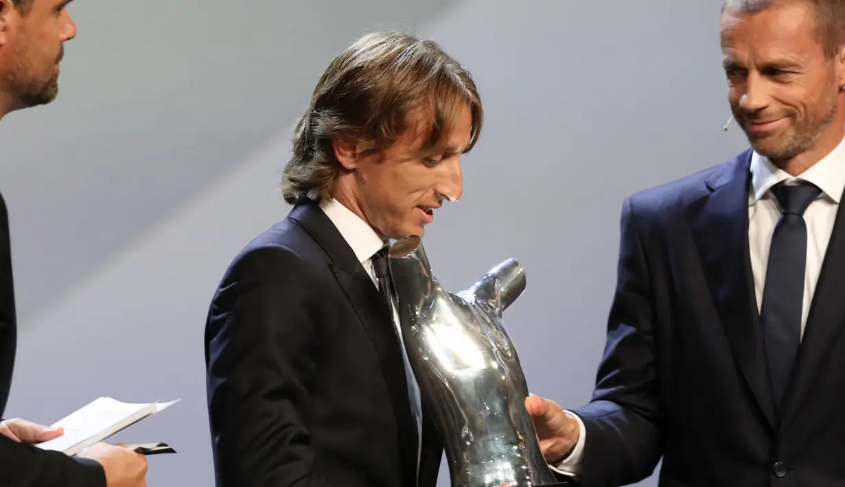 Gelandang Real Madrid asal Kroasia, Luka Modric menerima piala pemain terbaik UEFA dari presiden UEFA Aleksander Ceferin di The Grimaldi Forum di Monaco, (30/8). Modric mengalahkan Cristiano Ronaldo dan Mohamed Salah. (AFP Photo/Valery Hache)