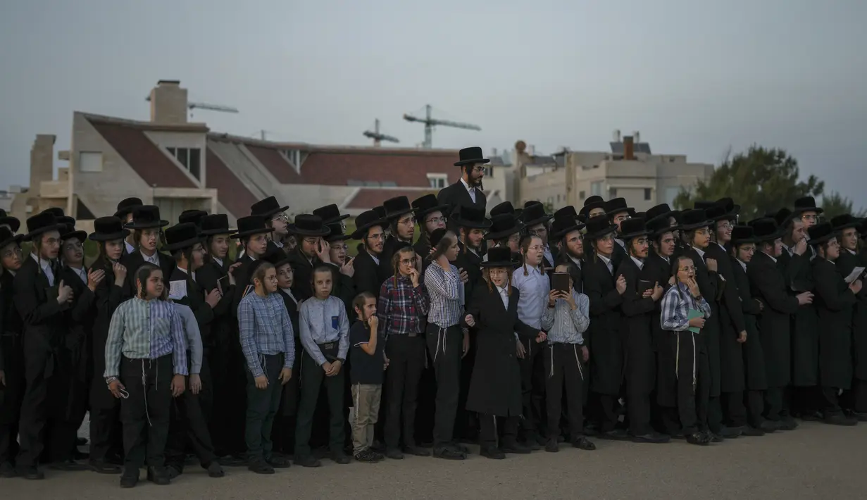 Seorang pria Yahudi Ultra-Ortodoks dari sekte Kiryat Sanz Hasidic mendengarkan rabi mereka di sebuah bukit yang menghadap ke Laut Mediterania saat mereka berpartisipasi dalam upacara Tashlich, di Netanya, Israel, Senin, 3 Oktober 2022. Upacara ini dilakukan sehari sebelum perayaan hari raya Yahudi, Yom Kippur, hari paling suci dalam tahun Yahudi yang dimulai pada Selasa. (AP Photo/Oded Balilty)