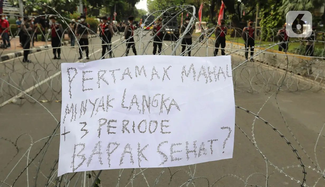 Sebuah poster diletakkan pada kawat berduri yang menjadi barikade saat aksi demo mahasiswa di kawasan Patung Kuda, Jakarta, Senin (4/11/2022). Mereka menyampaikan tuntutannya terkait kenaikan minyak goreng dan bahan bakar minyak (BBM). (Liputan6.com/Herman Zakharia)