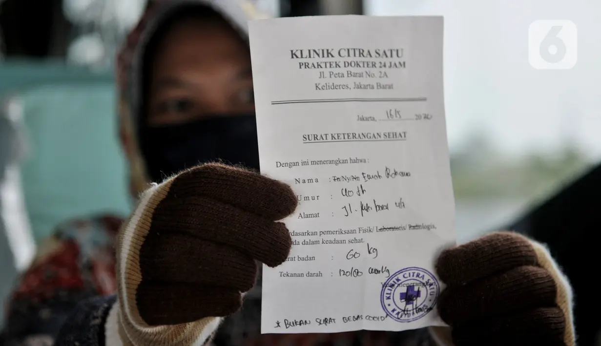Salah seorang penumpang menunjukkan surat keterangan sehat di Terminal Pulo Gebang, Jakarta, Minggu (17/5/2020).  Saat ini tercatat hanya ada 38 PO bus yang masih beroperasi dengan batas maksimal mengangkut penumpang mulai 6-10 orang dalam 1 bus. (merdeka.com/Iqbal S. Nugroho)
