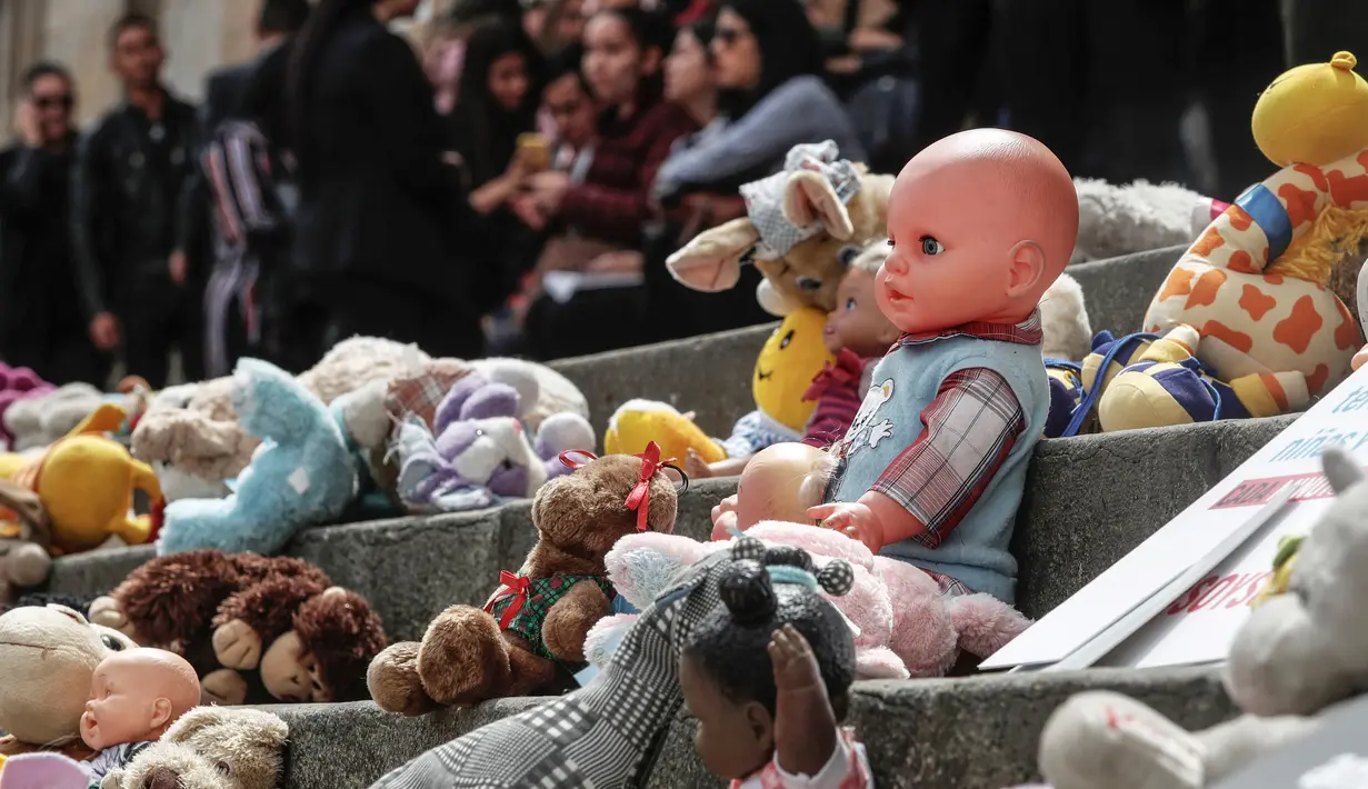 Boneka mainan diletakkan di halaman gedung Kongres Kolombia untuk memprotes kekerasan seksual terhadap anak-anak di Bogota, Selasa (20/11). Protes ini untuk mendorong pengaduan kasus pelecehan anak di hadapan pihak berwenang Kolombia (DANIEL MUNOZ/AFP)