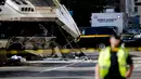 Seorang polisi berjaga di garis polisi di lokasi kejadian tabrakan dua bus di Newark, New Jersey (19/08) waktu setempat. Seorang pengemudi bus New Jersey Transit tewas dan 19 orang dirawat di rumah sakit. (REUTERS/Eduardo Munoz)