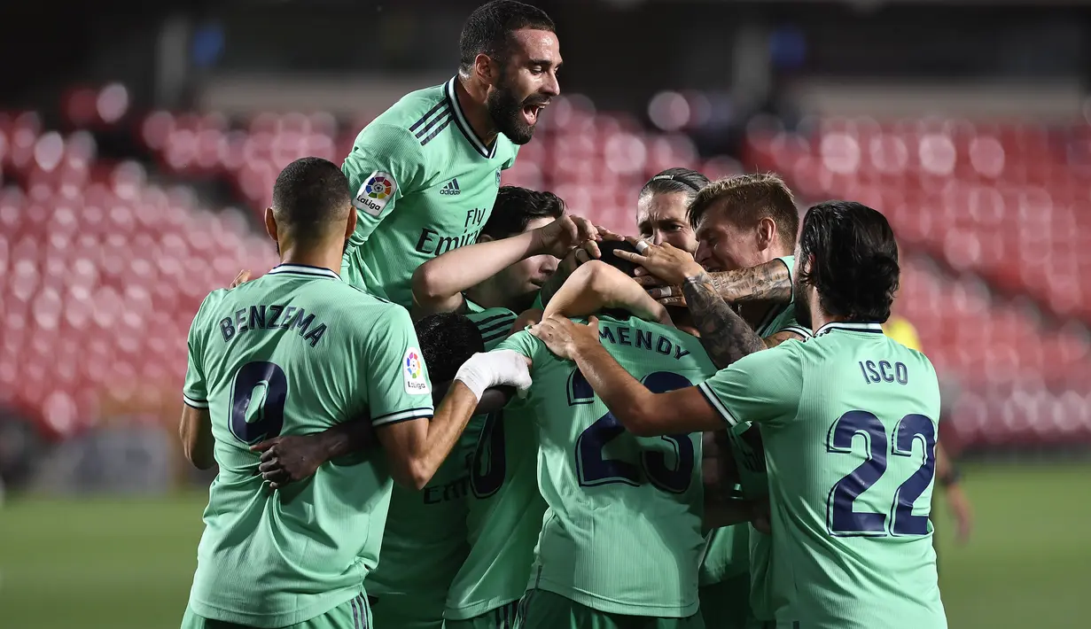Pemain Real Madrid merayakan gol yang dicetak Ferland Mendy ke gawang Granada pada laga lanjutan La Liga pekan ke-36 di di Estadio Nuevo Los Carmenes, Selasa (14/7/2020) dini hari WIB. Real Madrid menang 2-1 atas Granada. (AFP/Jorge Guerrero)