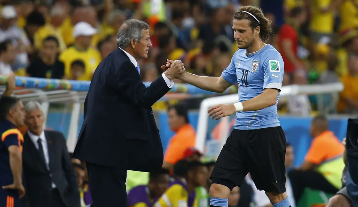 Diego Forlan (kanan), tertunduk keluar lapangan usai gagal membawa Uruguay masuk ke babak 8 besar Piala Dunia setelah kalah 0-2 dari Kolombia di Stadion Maracana, Rio de Janeiro, (29/6/2014). (REUTERS/Kai Pfaffenbach)