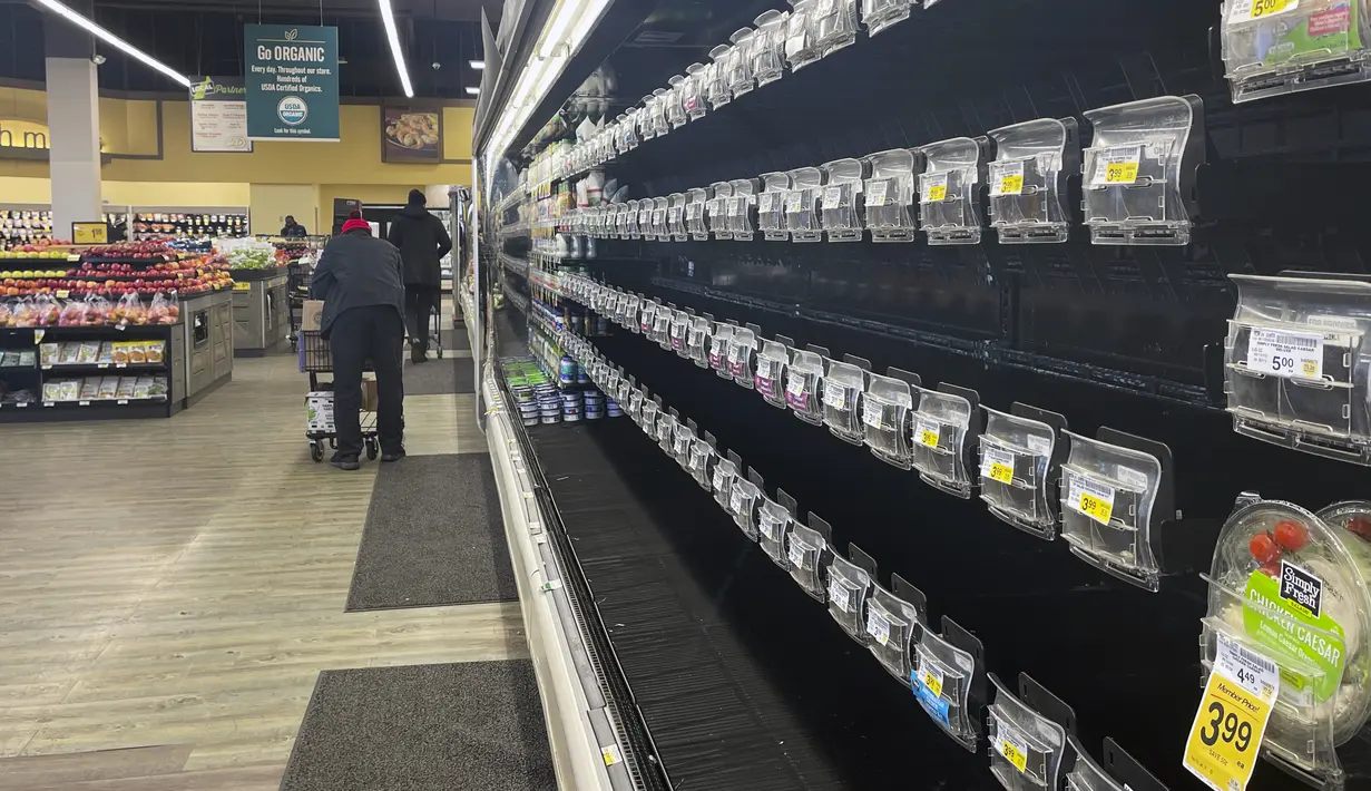 Pembeli berjalan melewati lorong kosong produk di Safeway, Washington, Selasa (11/1/2022). Varian Omicron yang sangat menular membuat pekerja sakit, menciptakan kekurangan tenaga kerja yang memengaruhi pengiriman produk dan pengisian kembali rak-rak toko di seluruh negeri. (AP Photo/Parker Purifoy)