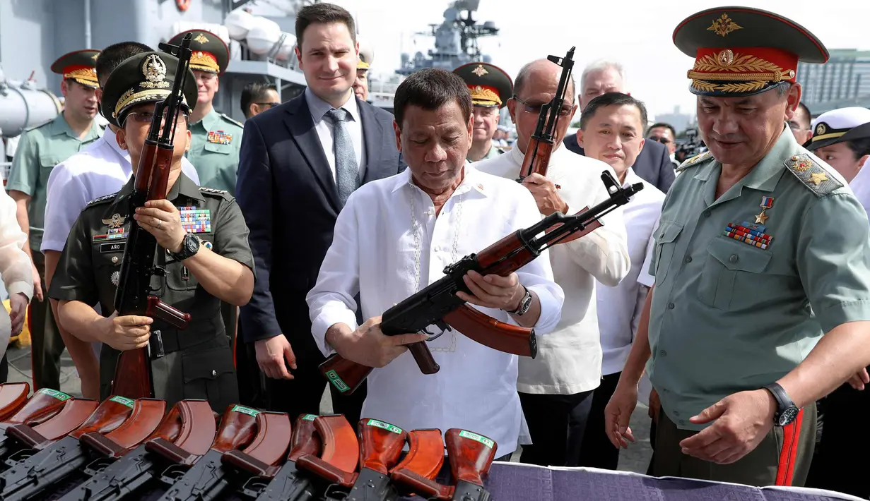 Presiden Filipina Rodrigo Duterte memeriksa senapan serbu AK-47 di kapal Admiral Panteleyev di pelabuhan Metro Manila, Filipina (25/10). 5.000 senapan AK-74M Kalashnikov dari Rusia disumbangkan untuk pemerintahan Filipina. (AFP Photo/Robinson Ninal)