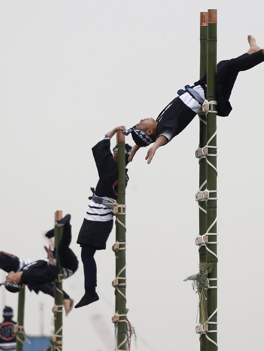 Anggota perkumpulan Edo saat menampilkan atraksi diatas ujung bambu di Tokyo, Jepang, (6/1). Atraksi ini dilakukan oleh para petugas pemadam kebakaran Tokyo.( REUTERS / Yuya Shino)