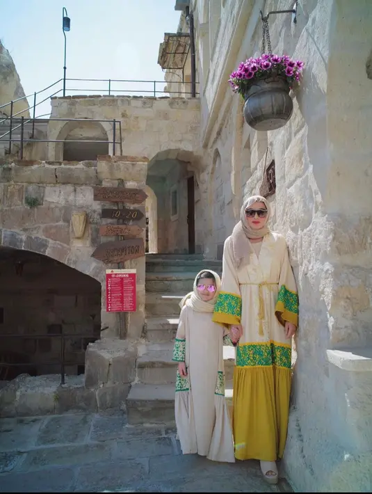 <p>Seragam Gamis berwarna kuning dan hijau adalah pilihan yang kompak untuk ibu dan anak. (instagram/queenarsy)</p>