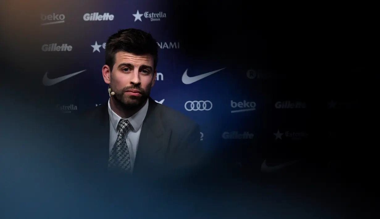 Bek Barcelona asal Spanyol, Gerard Pique menghadiri konferensi pers untuk secara resmi mengumumkan perpanjangan kontraknya di stadion Camp Nou, Senin (29/1). Bek timnas Spanyol itu meneken kontrak baru hingga 30 Juni 2022. (LLUIS GENE/AFP)