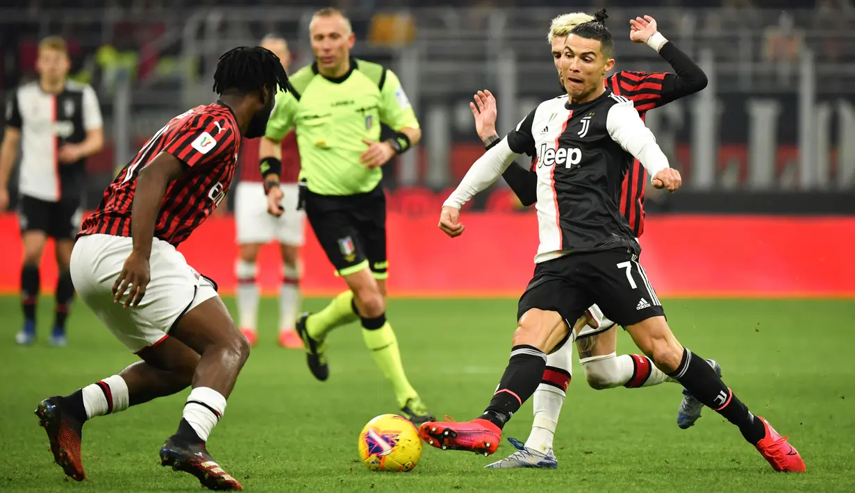 Pemain Juventus Cristiano Ronaldo (kanan) membawa bola mencoba melewati pemain AS Milan Frank Kessie pada pertandingan Coppa Italia di Stadion San Siro, Milan, Italia, Kamis (13/2/2020). Pertandingan berakhir 1-1. (Massimo Paolone/LaPresse via AP)