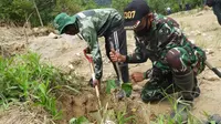 Seorang anggota TNI dan warga setempat menutup lubang dengan bibit kemiri saat digelar Patroli Simpatik oleh BBTNL di lokasi eks PETI Dongi-Dongi, Rabu (22/4/2020). (Foto: Humas BBTNLL).