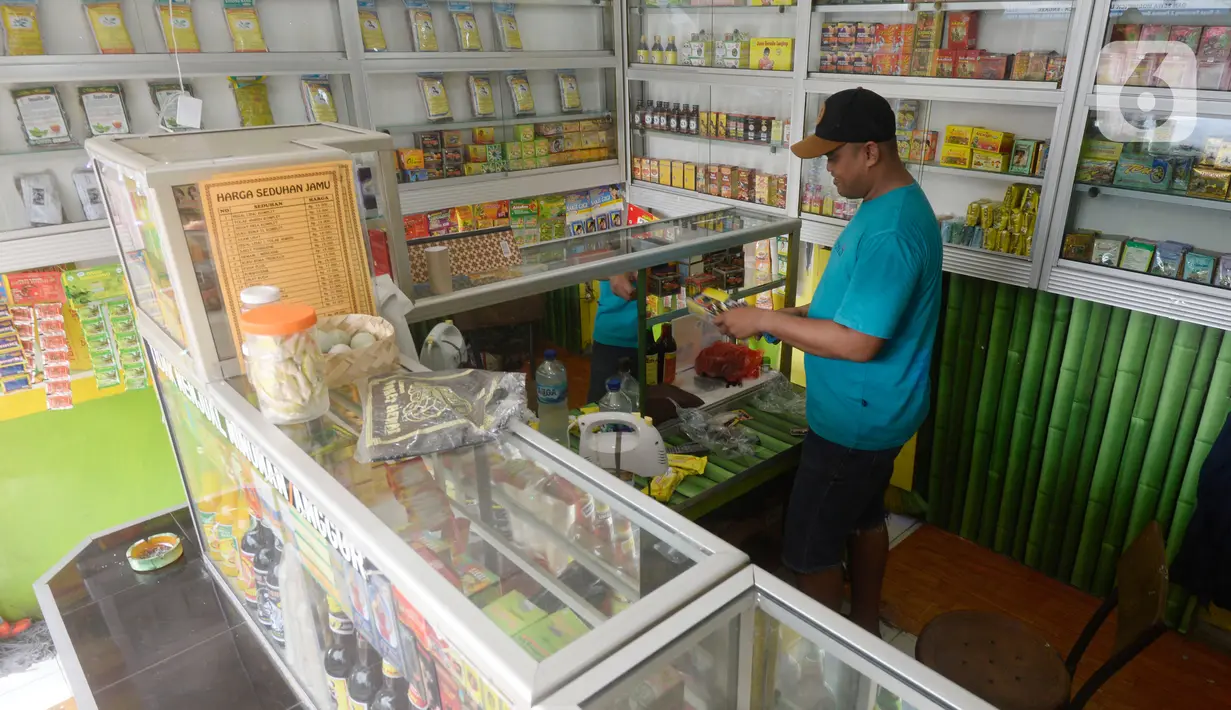 Hendri (37) penjual jamu aduk sedang merapikan daganganya sambil menunggu pembeli di kawasan Pamulang, Tangerang Selatan, Banten, Senin (28/9/2020). (merdeka.com/Dwi Narwoko)