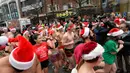 Peserta memulai lomba menyusuri Boylston Street selama Santa Speedo Run di Boston, Massachusetts, Sabtu (14/12/2019). Speedo Run adalah perlombaan lari menjelang Natal dengan peserta pria hanya menggenakan celana dalam dan wanita memakai bikini beserta topi ala Sinterklas. (Joseph Prezioso/AFP)