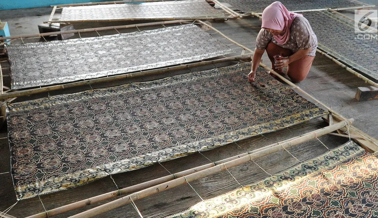 Seorang ibu membuat batik di Kampung Batik Puswasedar kawasan Geopark Ciletuh, Sukabumi, Jawa Barat, Sabtu (22/9). Batik di sini dikenal dengan batik pakulonan dan dijual dengan harga Rp 200 ribu hingga Rp 1,5 juta per lembar. (Merdeka.com/Arie Basuki)